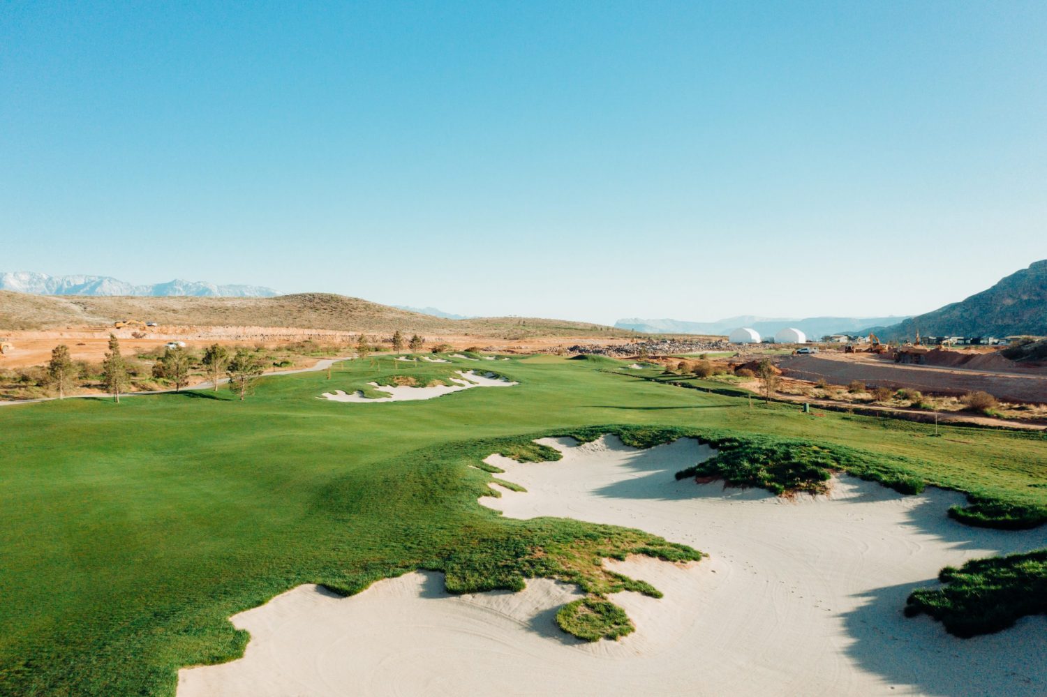 Copper Rock Golf Course canyon hole with desert vegetation red sandstone walls and green fairway